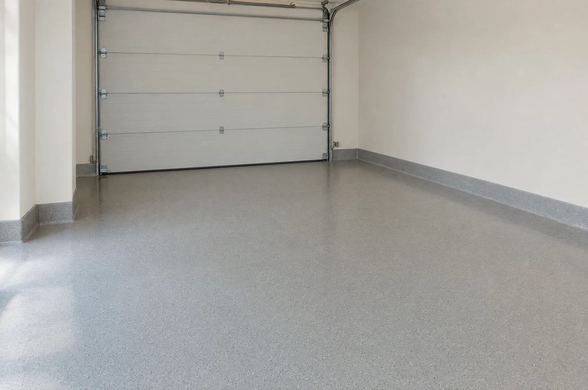 Frisch versiegelter Garagenboden in hellem Grau mit Hohlkehle zur Wand