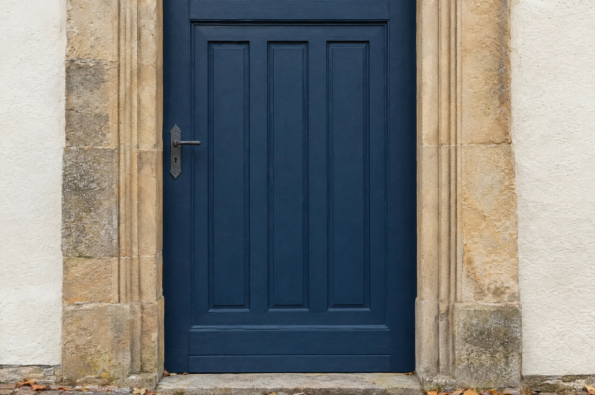 Frisch gestrichene Kirchentür in Marineblau in einem Sandsteinportal