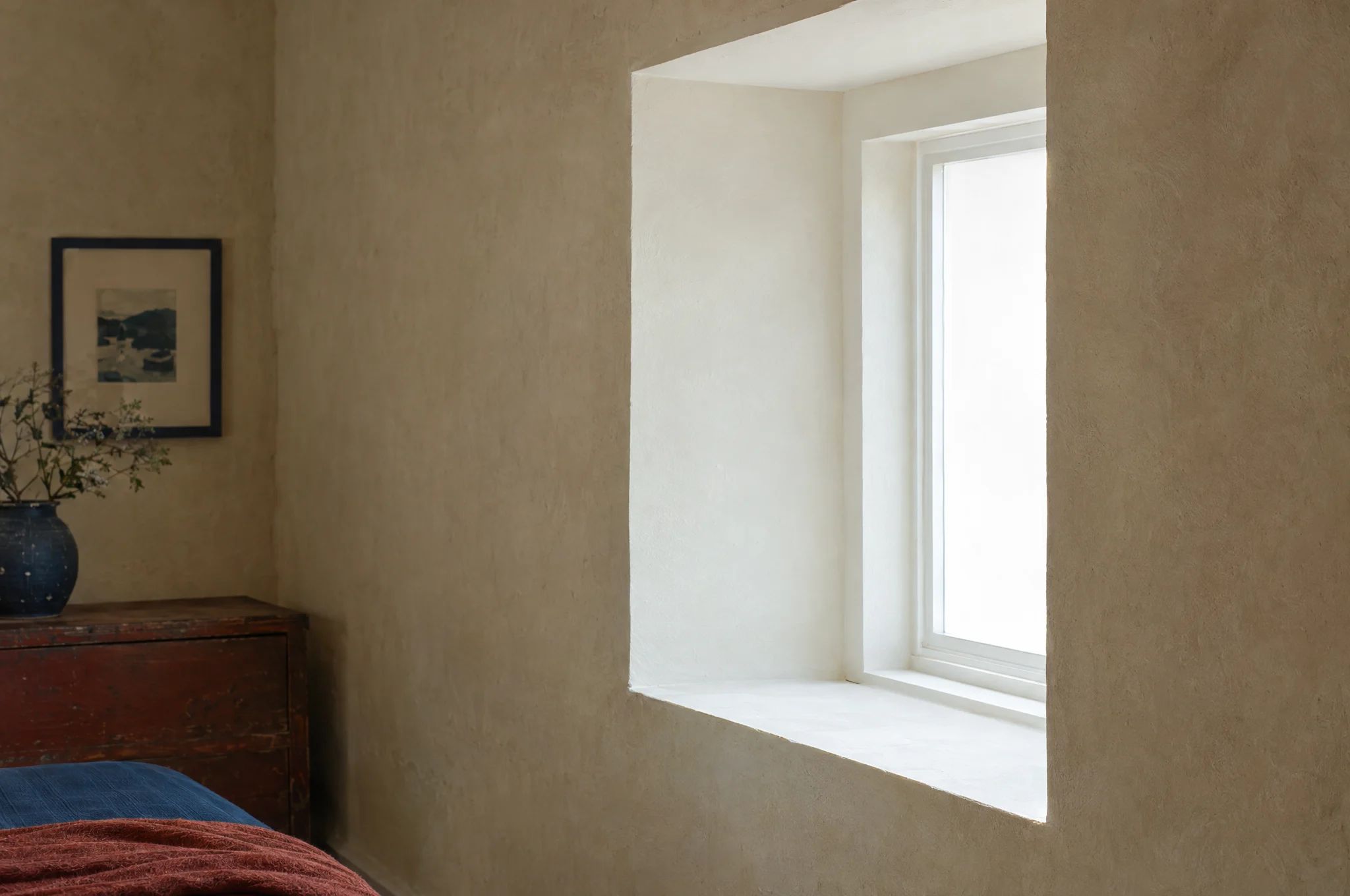 Frisch verputzte und weiß gestrichene Fensterlaibung im Tageslicht