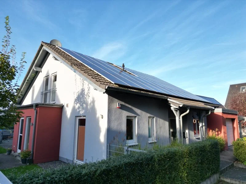 Weiß gestrichenes Einfamilienhaus mit Solardach