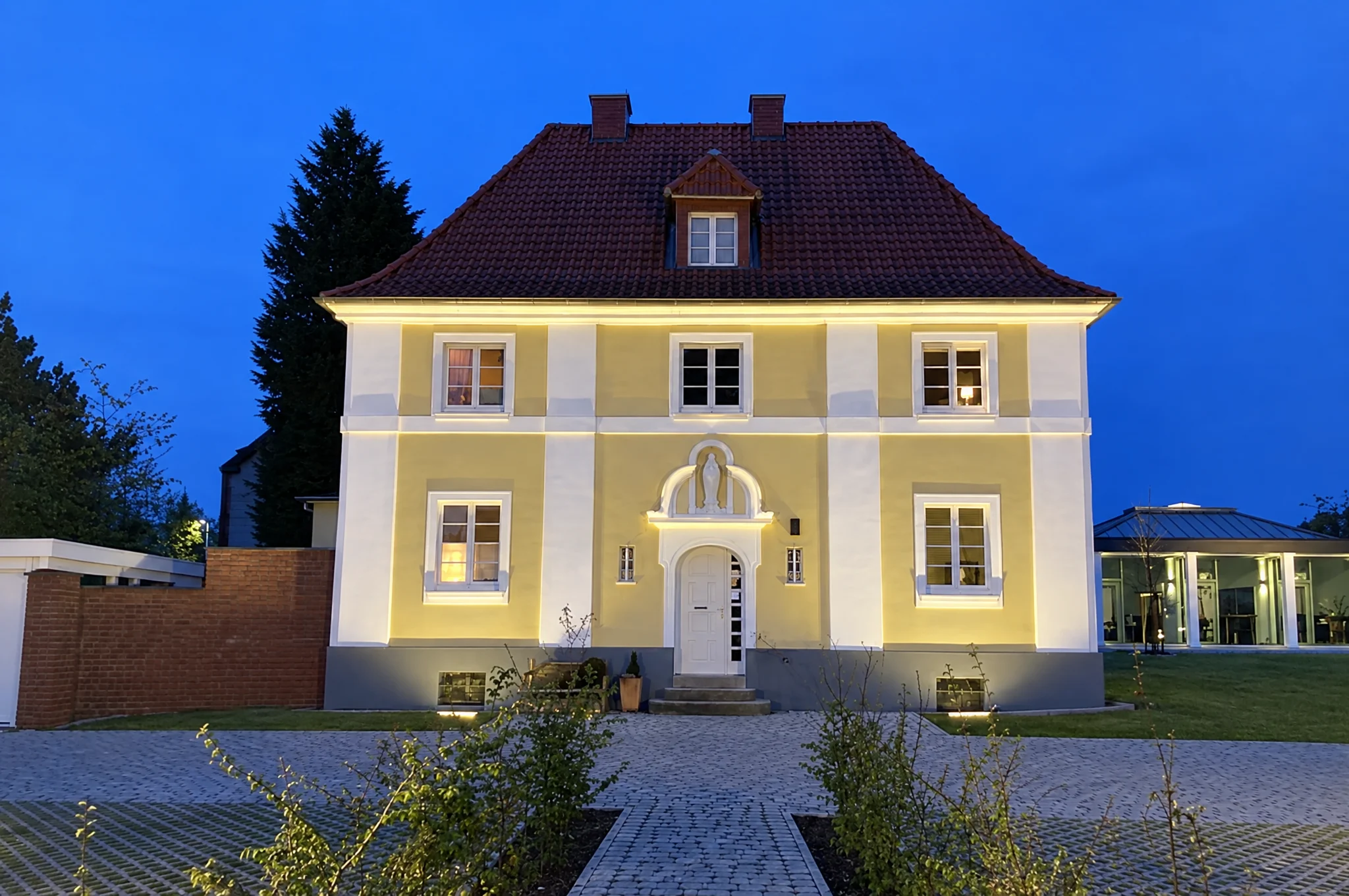 Frisch gestrichenes Pfarrhaus St. Peter und Paul in Hamm in der Abenddämmerung