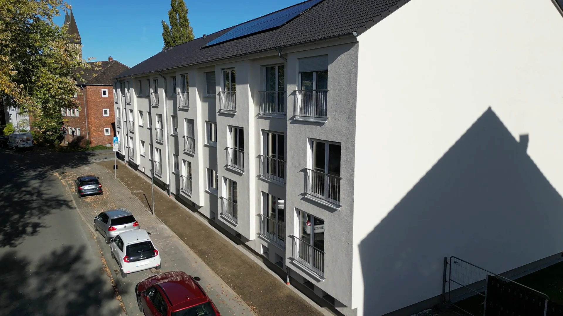 Frisch gedämmte und verputzte Fassade eines Mehrfamilienhauses der Hammer Gemeinnützigen Baugesellschaft